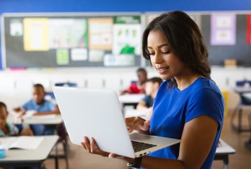 Teacher checking laptop in the classroom