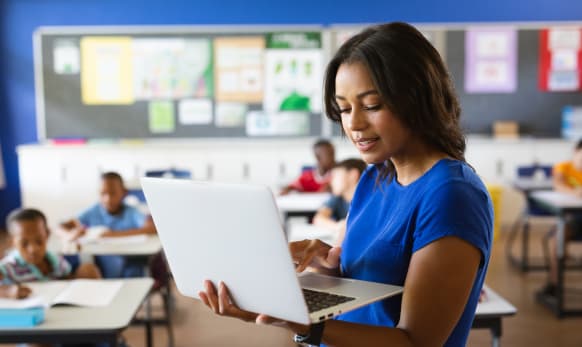 Teacher checking laptop in the classroom