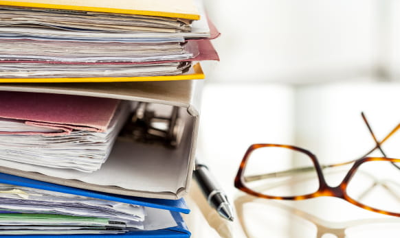 piles of paper-filled binders