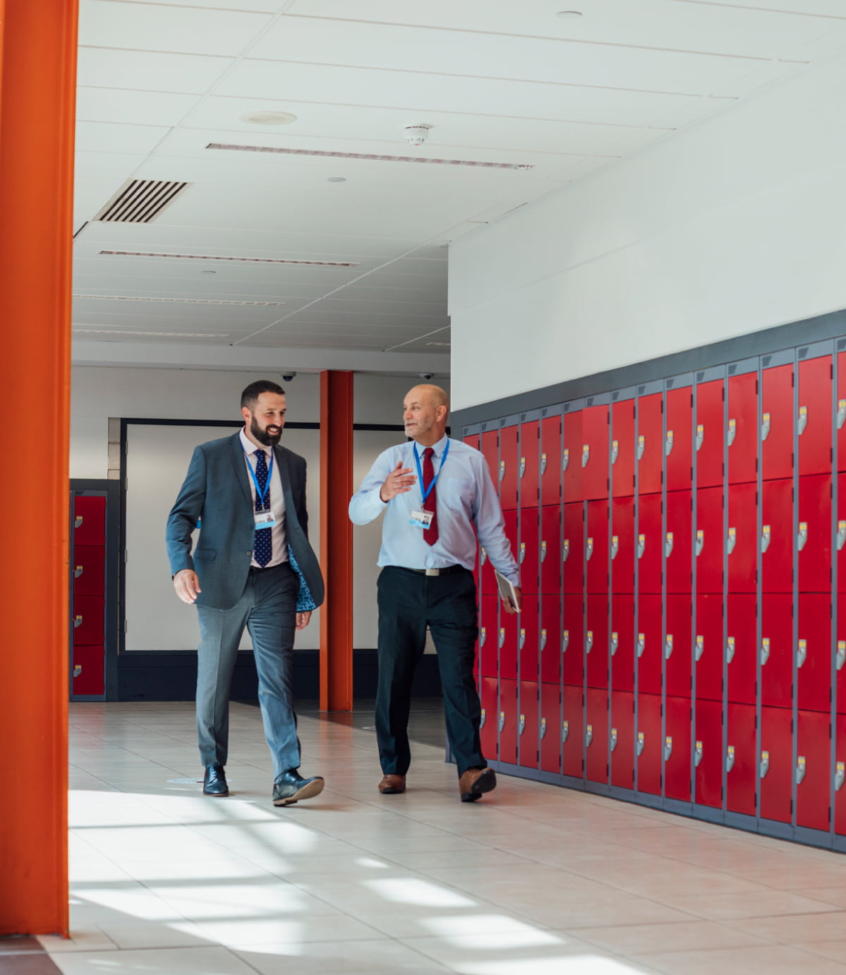 Two K‑12 leaders walking through a school hallway