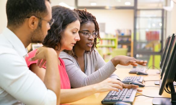 Woman looking at different systems with colleagues