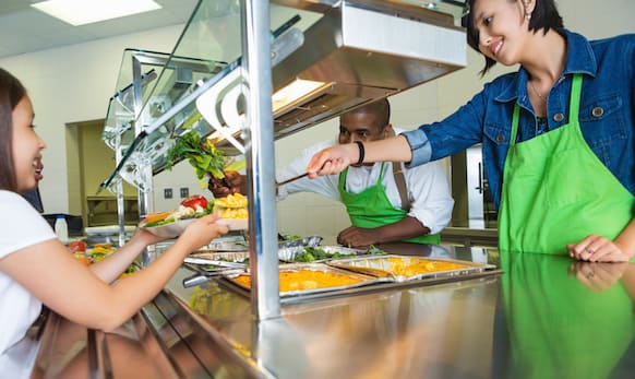 School cafeteria worker serving student