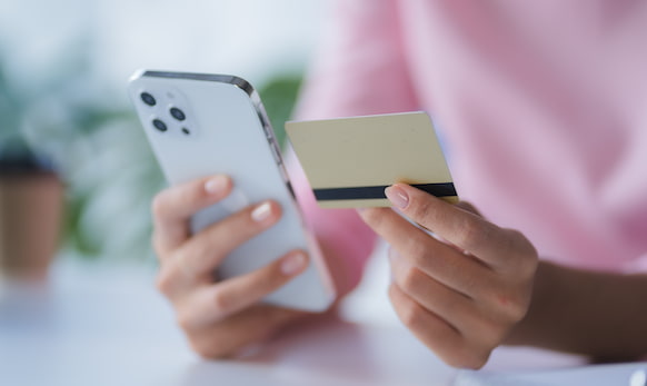 Woman holding credit card next to her phone